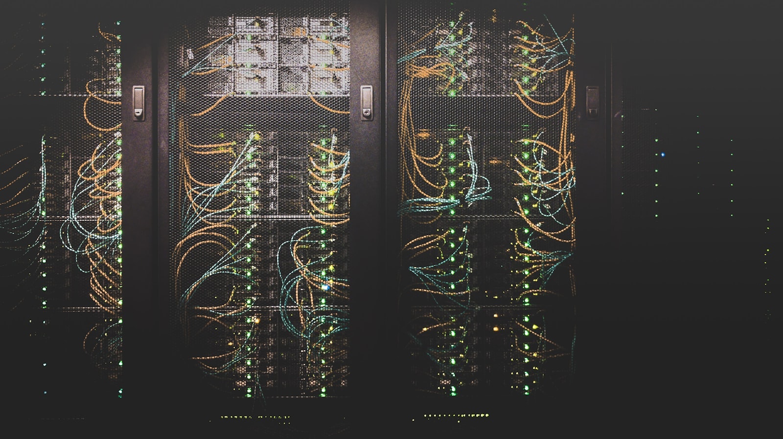 Server racks lit by green and amber status lights and patch cabling.